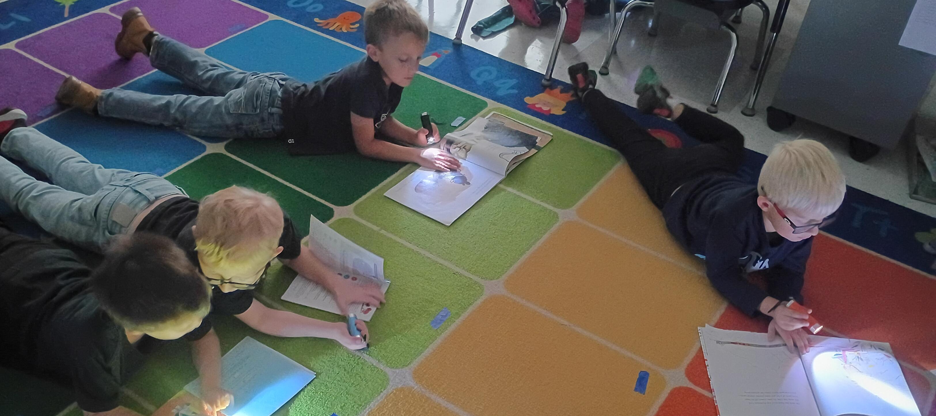 West First graders having some fun reading with flash lights.
